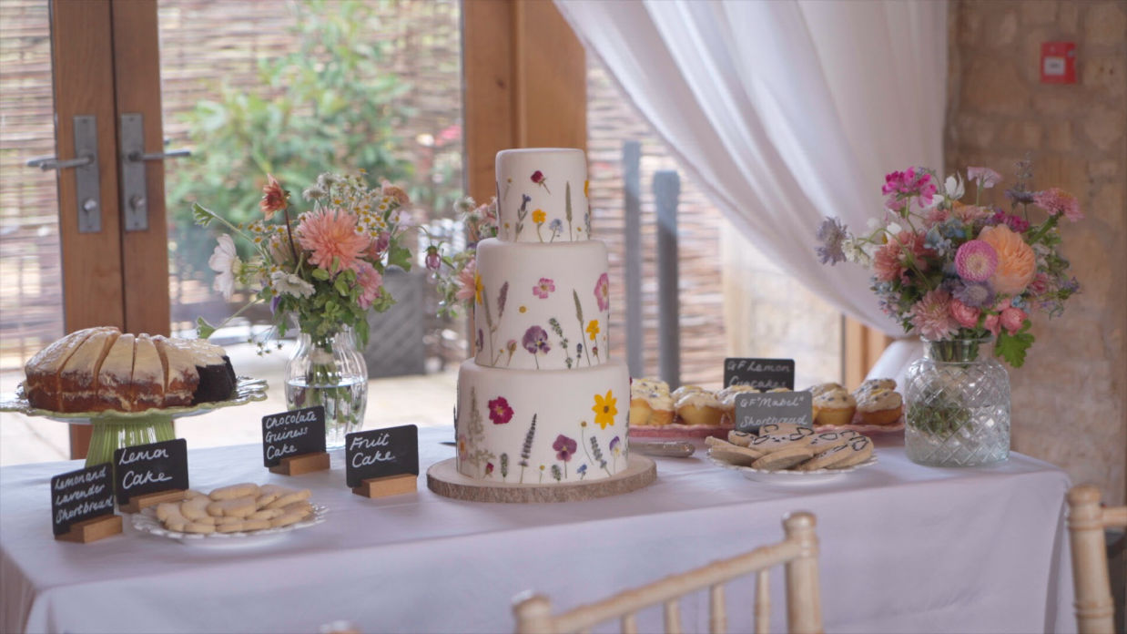 wedding cakes and flowers on table in the barn